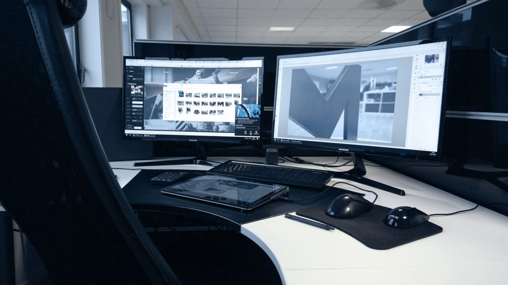 Data-oppsettet til en medarbeider hos Drift Partner, skrivebrett og to dataskjermer